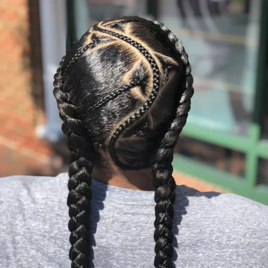 Back view of a woman's head with two detailed French braids styled at Uniq Braiding Salon.