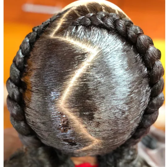 Top view of a client's French braids styled in a crown braid with zigzag parting at Uniq Braiding Salon.
