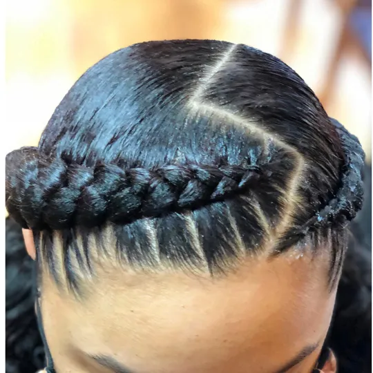 Close-up of sleek French braids styled in a crown braid.