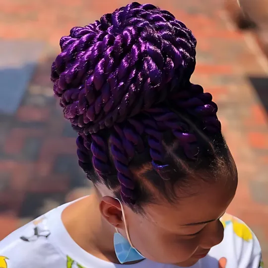 Client with large purple Senegalese twists styled in a high bun outside Uniq Hair Braiding Salon.