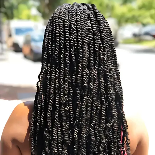 Back view of woman with spring twists hairstyle walking outside.