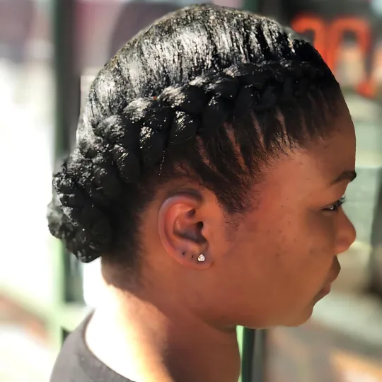 Side view of a woman with sleek, braided French braid hairstyle.