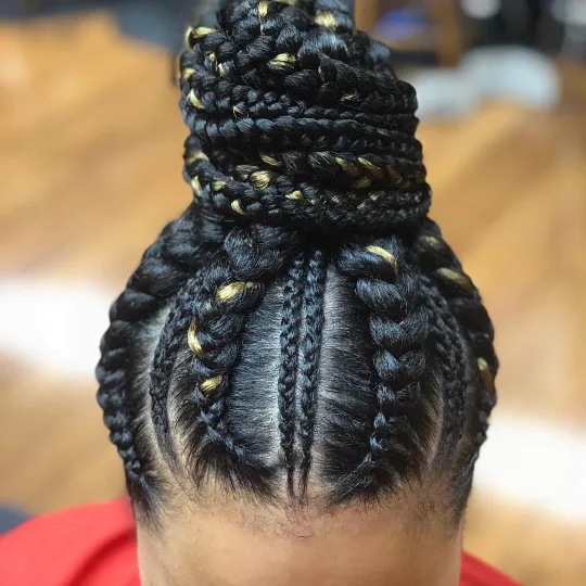 Client with intricate stitch braids styled into a high bun at Uniq Braiding Salon.