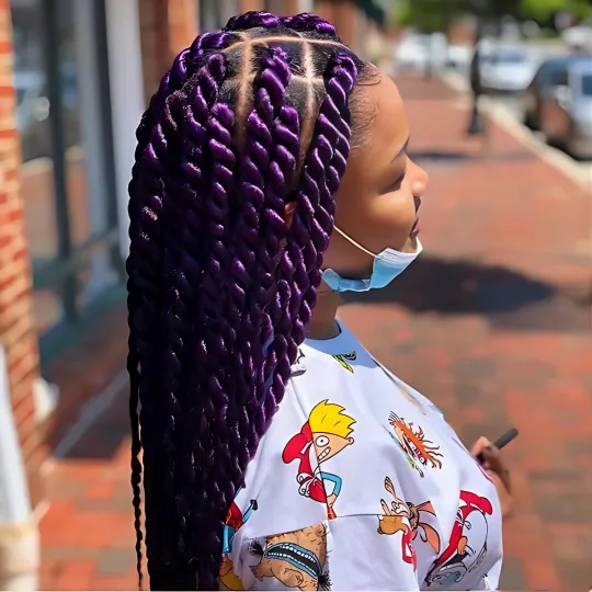 Client with long purple Senegalese twists standing outside Uniq Hair Braiding Salon.