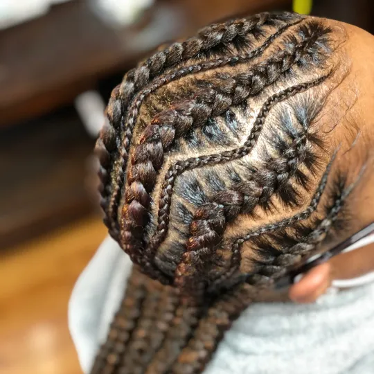 Client with intricate wavy stitch braids at Uniq Braiding Salon.