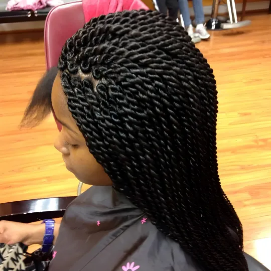 Client with neat Senegalese twists seated in Uniq Hair Braiding Salon.